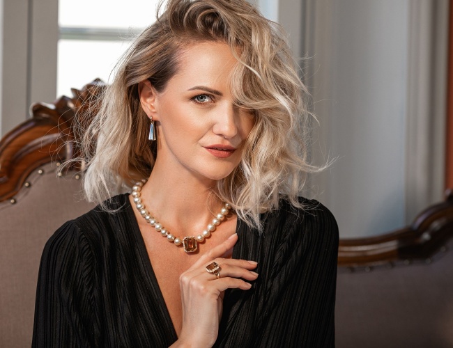 woman in black clothing wearing necklace and ring