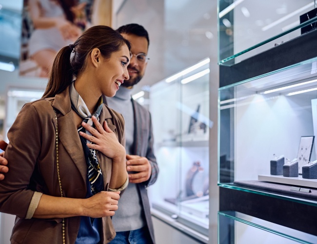 a smiling woman checking on a necklace